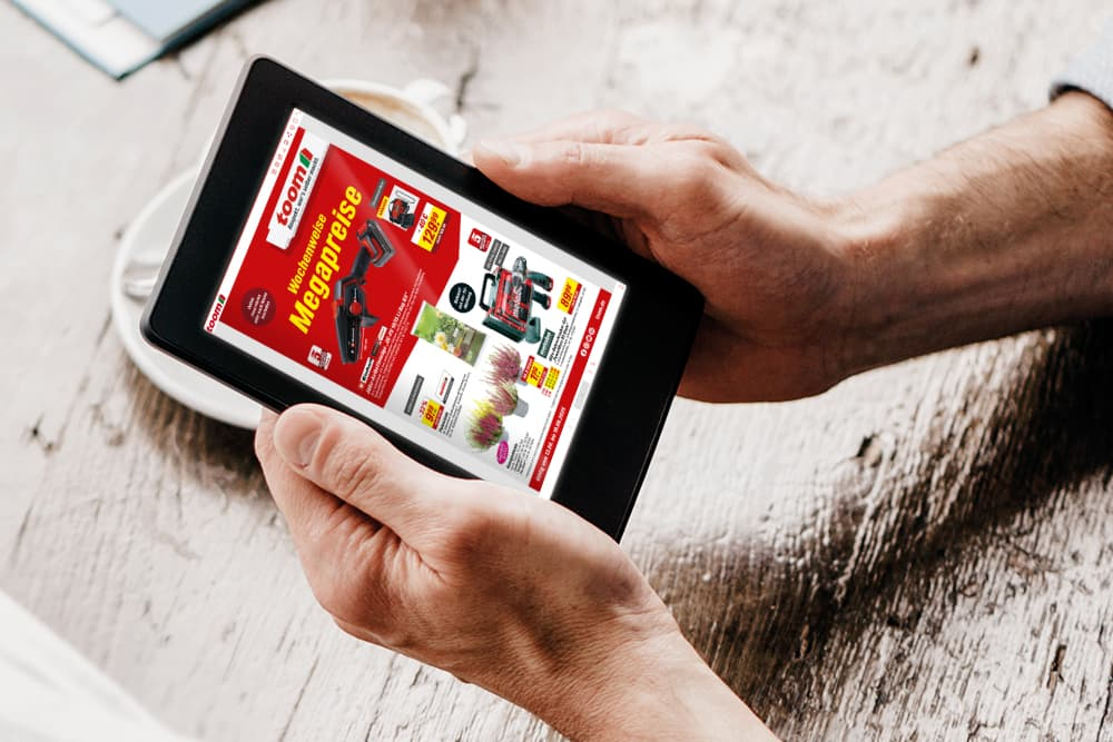 Eine Person schaut sich einen digitalen Baumarktprospekt auf einem Tablet an.