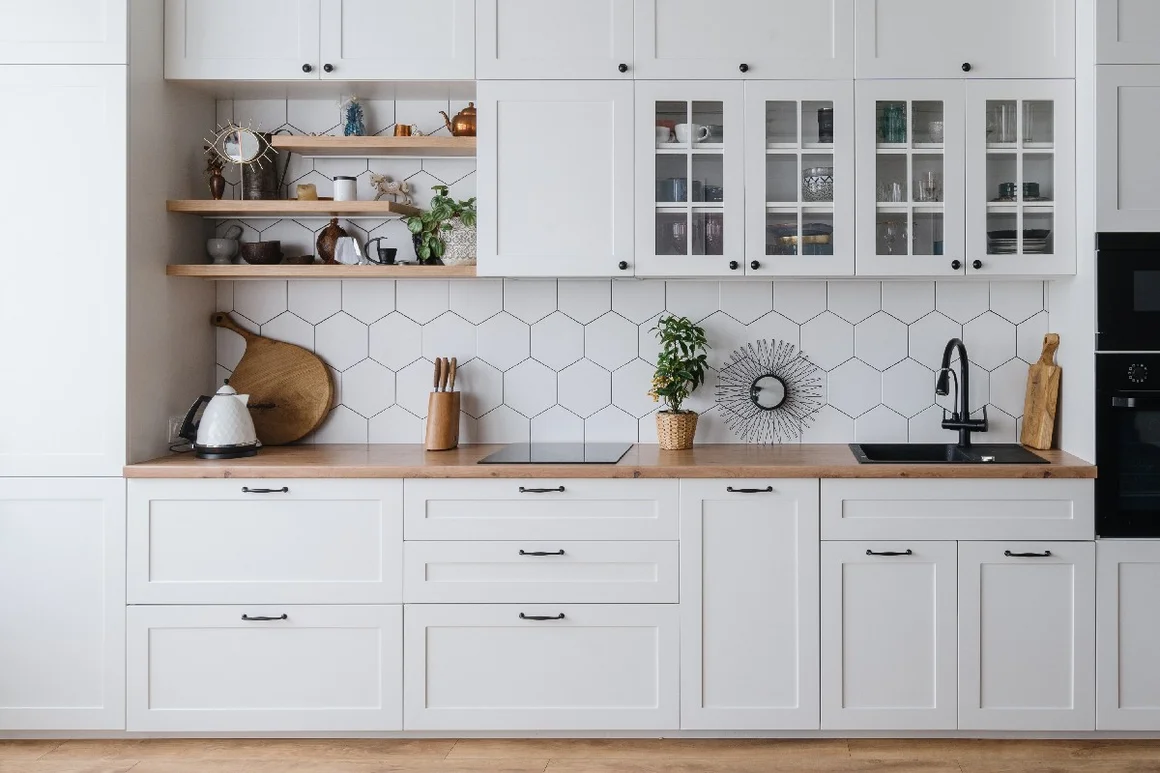 Stilvolle, moderne Küche mit weißen Schränken und Holzarbeitsplatte.