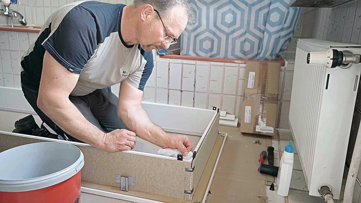 Person baut Schrank zusammen