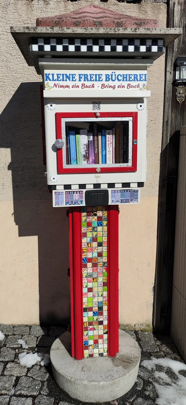 Ein bunt verzierter öffentlicher Bücherschrank mit der Aufschrift 'Kleine freie Bücherei'.