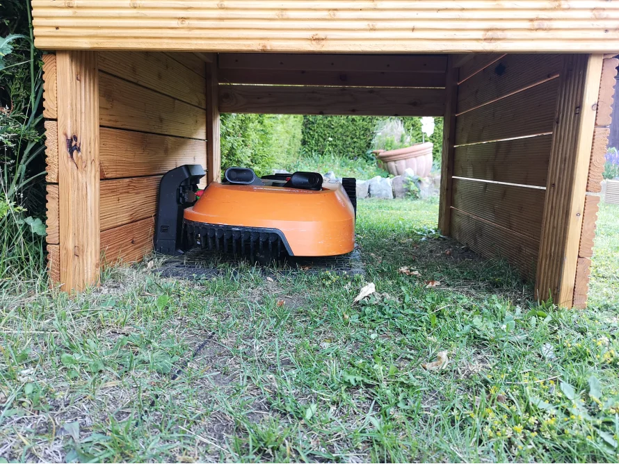 Roboter-Rasenmäher in einer Garage aus Holz