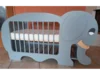 Ein blaugraues Babybett in Form eines Elefanten.