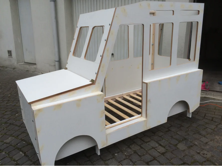 Unfertiges Bettgestell aus Holz in Form eines Autos
