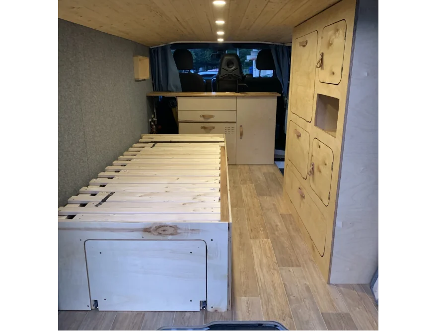 Innenausbau eines Campingbusses mit Bett und Schränken
