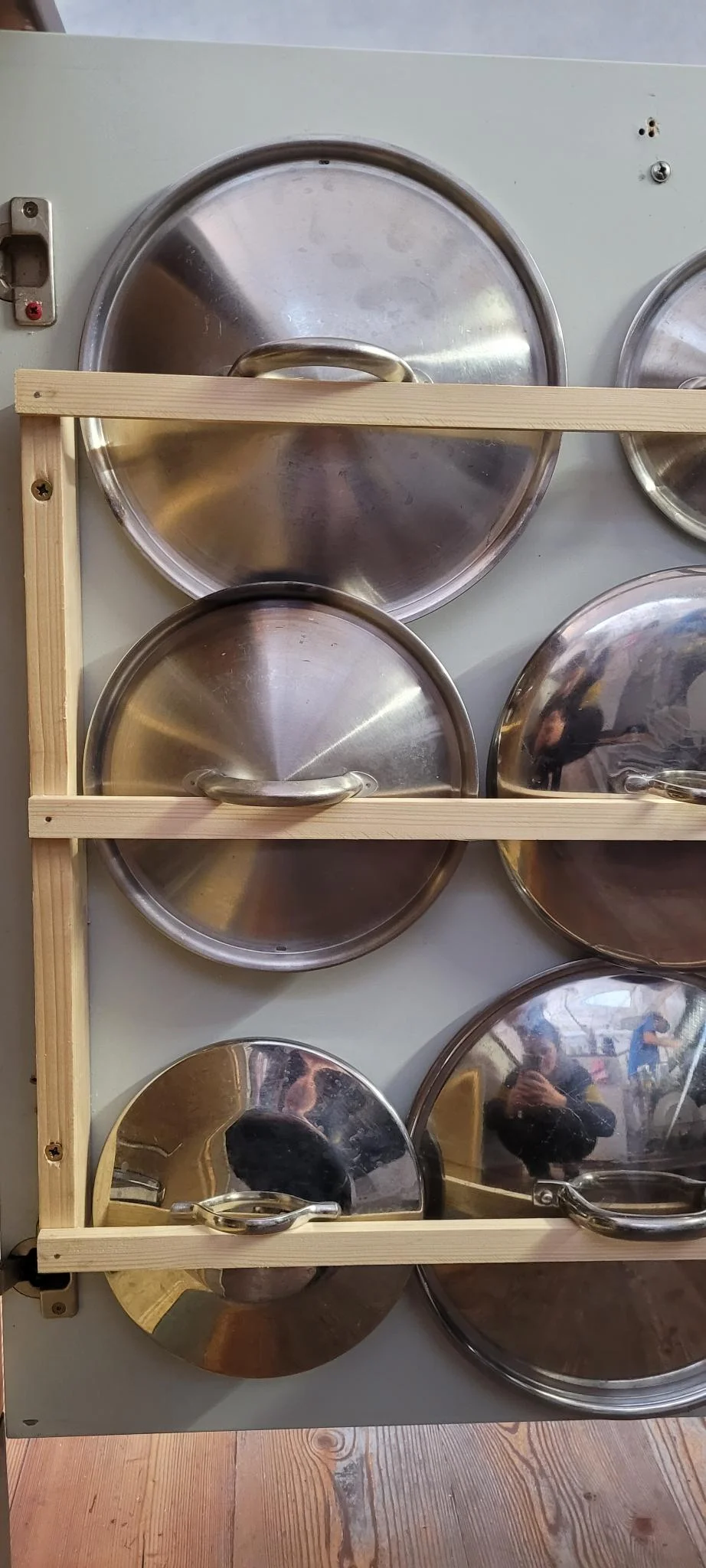 Ein selbstgebauter Halter aus Holz für Topfdeckel aus Edelstahl.