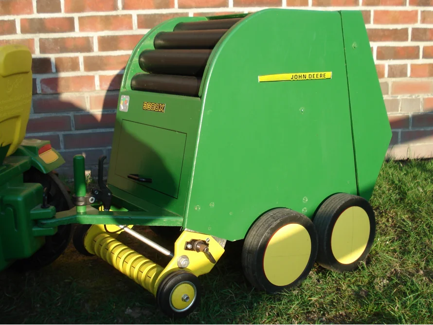 Grünes Spielzeug-Heugerät mit gelben Rädern