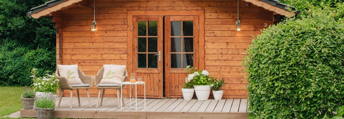 Gartenhaus aus Holz mit Terrasse und Stühlen