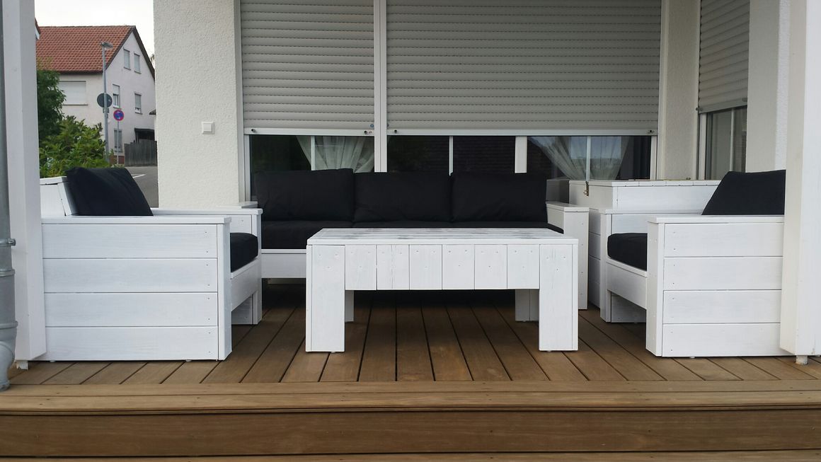 Weiße Gartenmöbel auf einer Holzterrasse