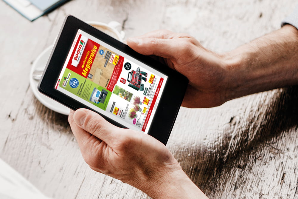 Eine Person schaut sich einen digitalen Prospekt auf einem Tablet an.