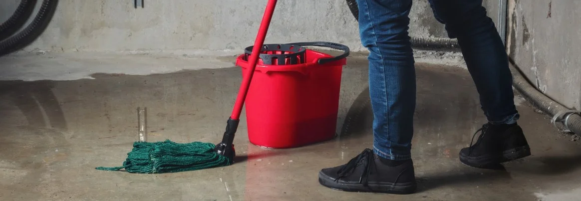 Person wischt den Boden im Keller.
