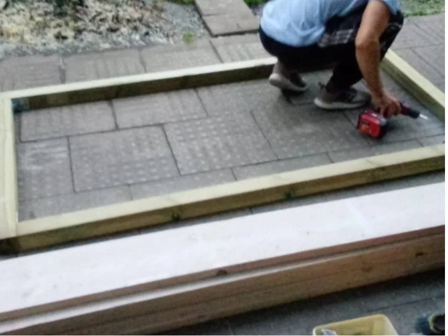 Person baut einen Holzrahmen mit Akkuschrauber