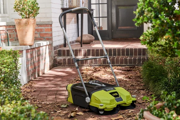 Kehrmaschine auf einem Gehweg mit Laub