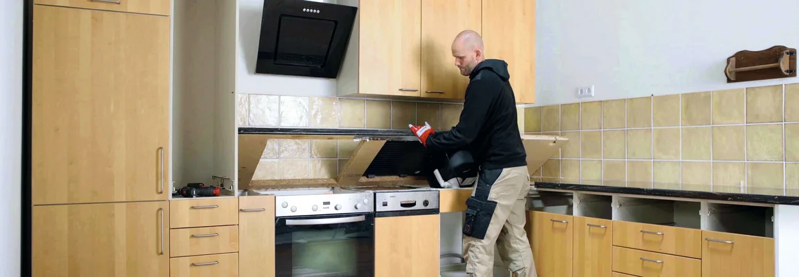 Person montiert Küchenschränke