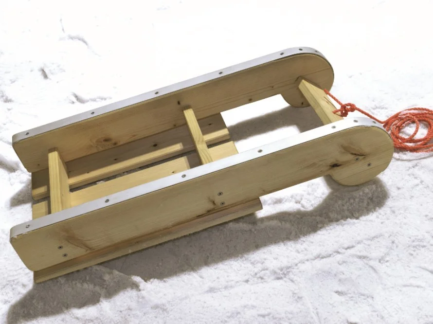 Holzschlitten im Schnee