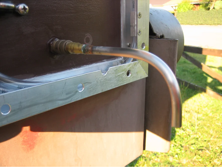 Gebogenes Metallrohr an Holzwand