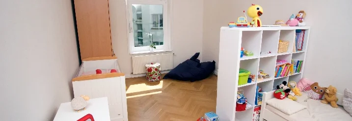 Helles Kinderzimmer mit Kinderbett und Spielzeug
