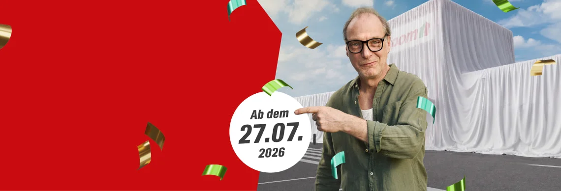 Ein Mensch zeigt auf das Datum einer Neueröffnung vor einem verhüllten Gebäude.