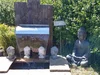 Gartenszene mit Buddhafiguren und einem Wasserspiel.