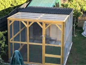 Holzrahmen eines Geheges mit Wellblechdach