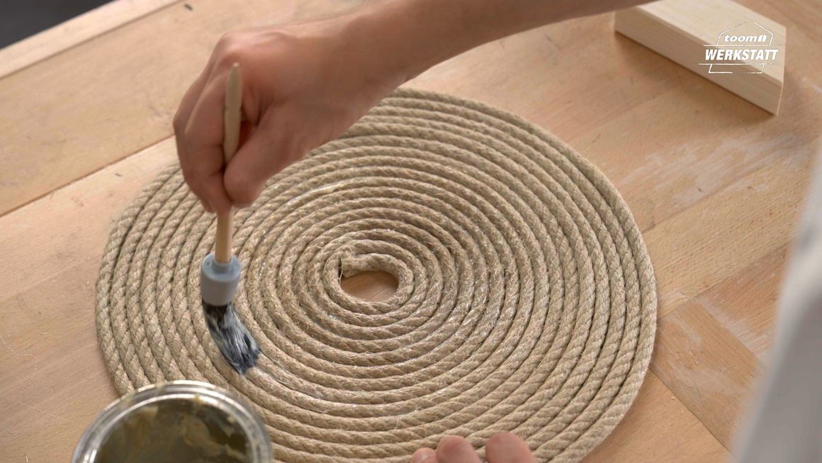 Person bestreicht Seil mit Kleber