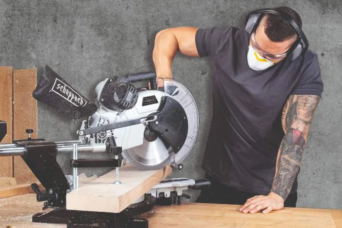 Person sägt Holz mit Kappsäge