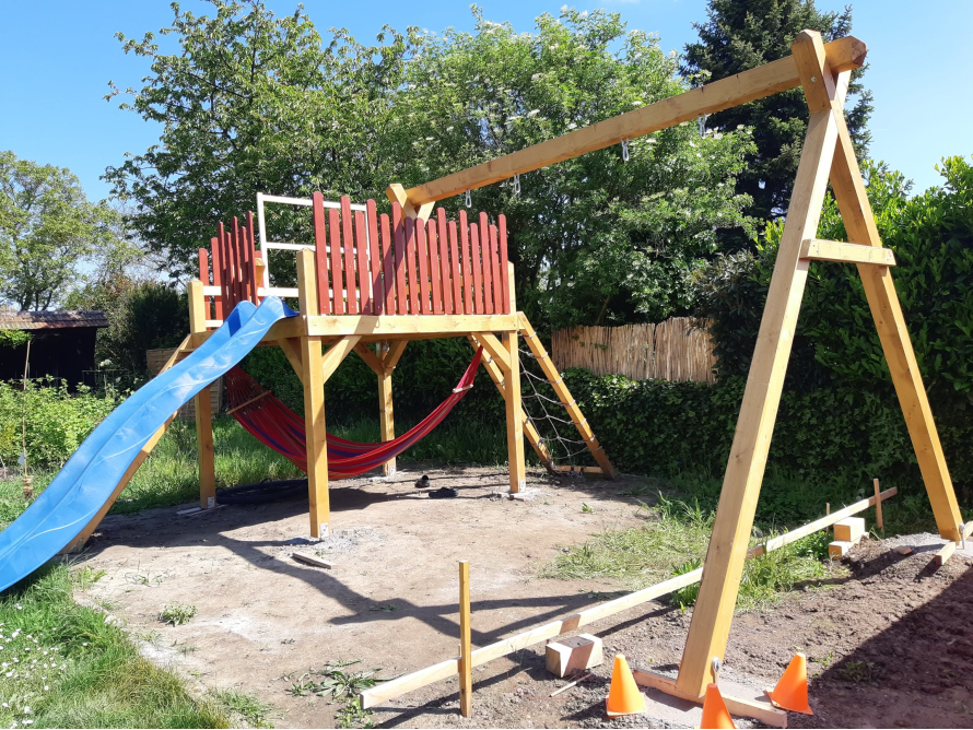 Unfertiger Holzspielplatz mit Schaukel und Rutsche