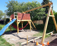 Unfertiger Holzspielplatz mit Schaukel und Rutsche