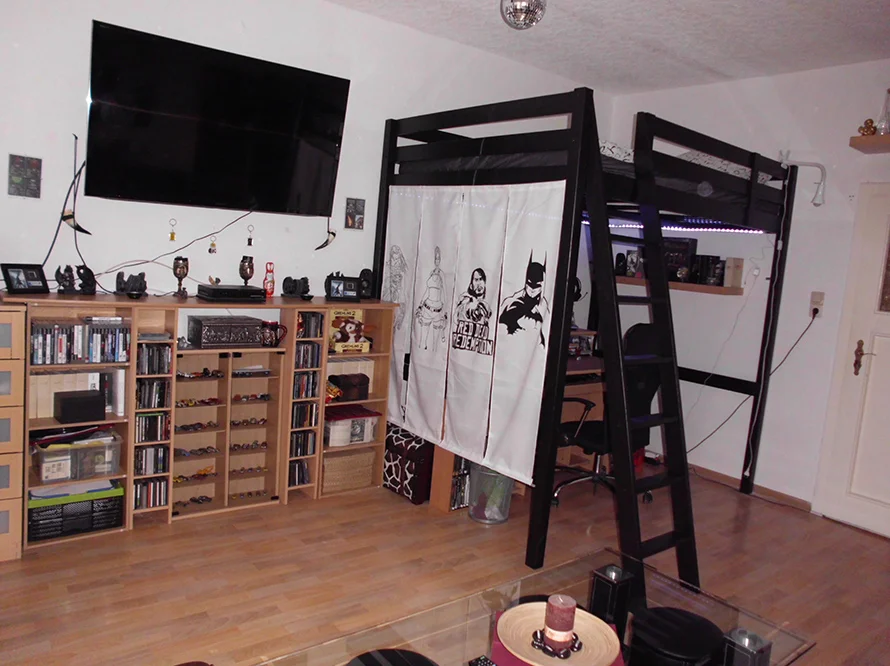 Ein Zimmer mit Hochbett und Regalen.