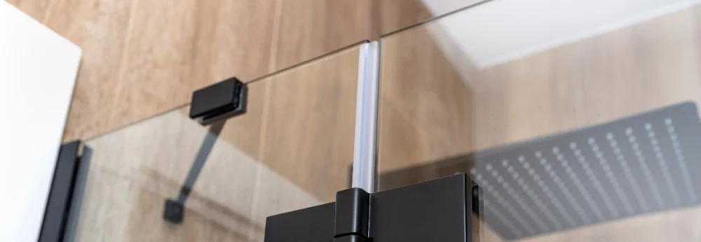 Schwarze Duschtürscharniere an Glaswand