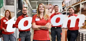 toom Mitarbeiter Fünf Personen in roter Arbeitskleidung im toom Baumarkt