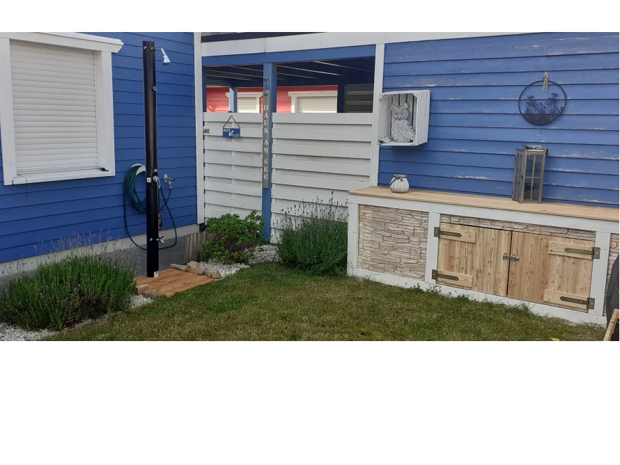 Gartendusche an blauem Gartenhaus