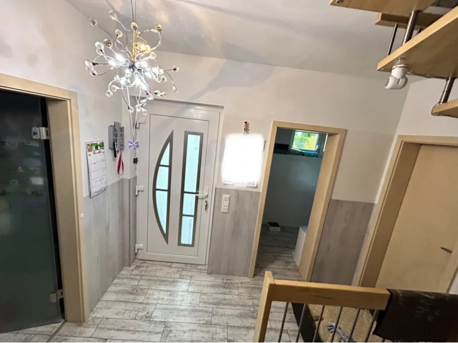 Ein Flur mit weißer Tür und Fliesenboden.