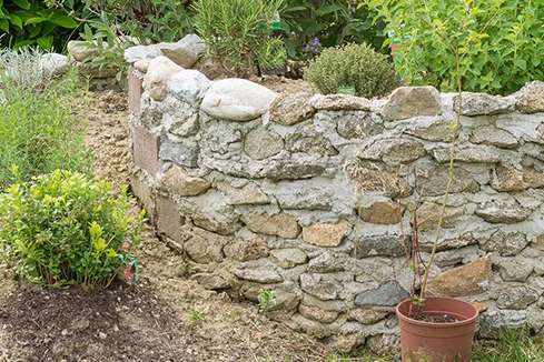 Kräuterspirale aus Steinen im Garten