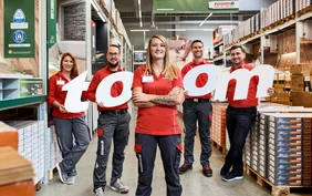 Fünf Azubis im toom Baumarkt mit toom Buchstaben