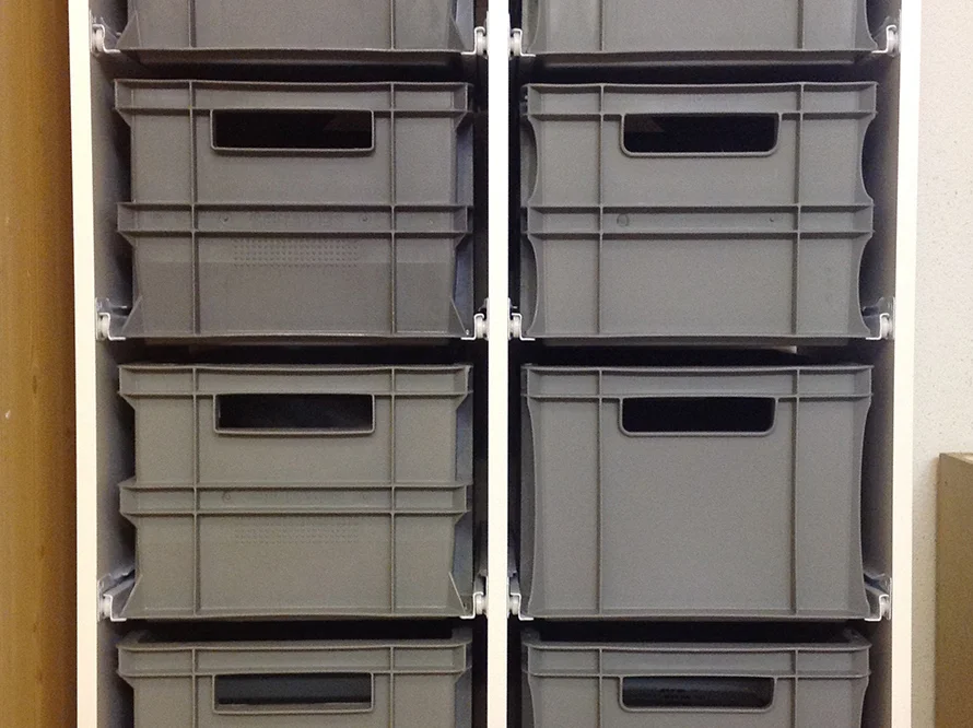 Graue Kunststoffbehälter in einem Regal