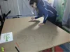 Person zeichnet mit Stift auf Holzplatte