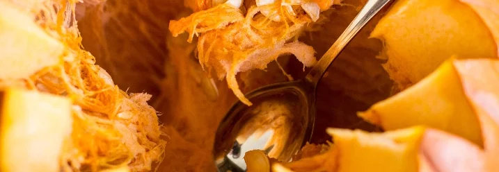 Aushöhlen eines Kürbisses mit einem Löffel