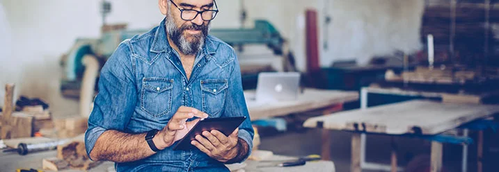 Person mit Tablet in Werkstatt