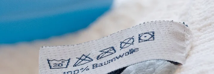 Ein Pflegeetikett auf einem weißen Stoff.