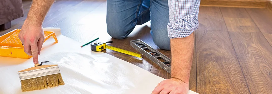 Person trägt Kleister mit Pinsel auf