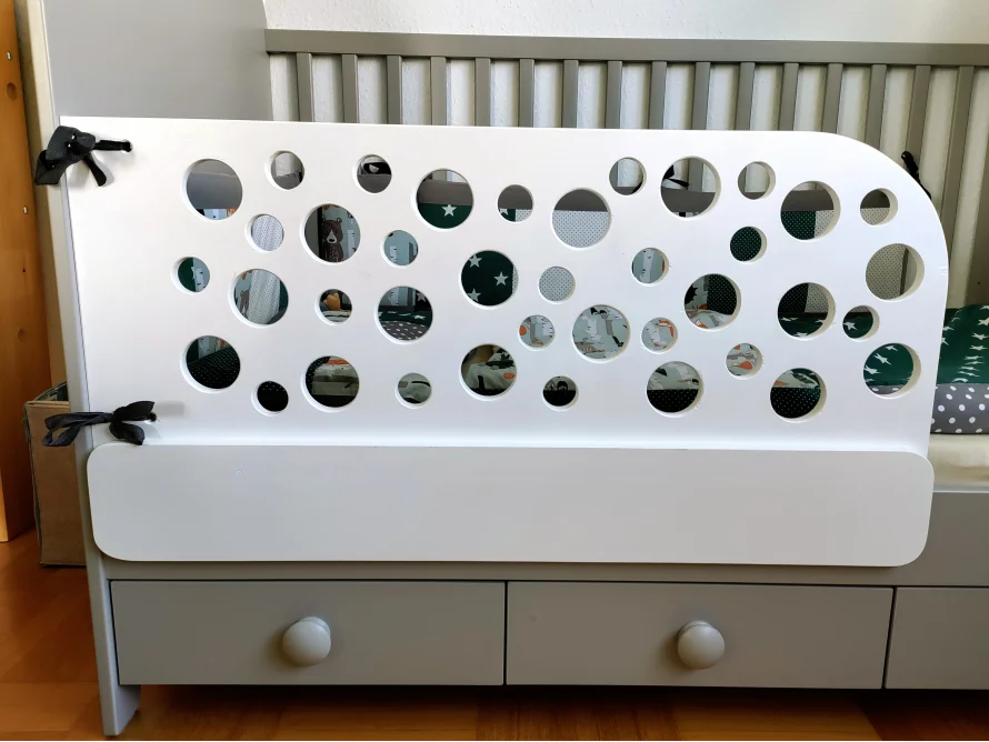 Weißes Babybett mit rundem Gitter