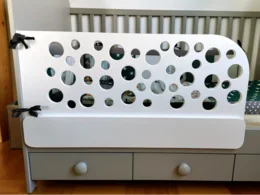 Weißes Babybett mit rundem Gitter