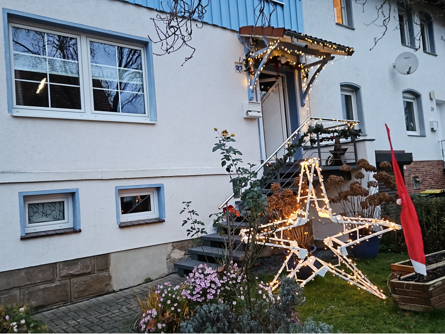 Weihnachtsstern aus Lichtern vor Haus