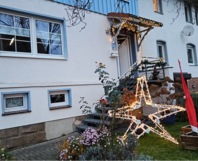 Weihnachtsstern aus Lichtern vor Haus