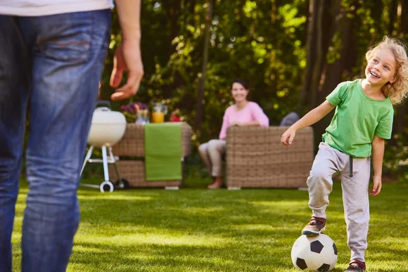 Kind mit Fußball im Garten