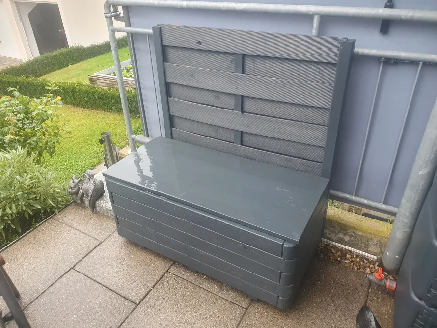 Graue Gartenbank mit Stauraum