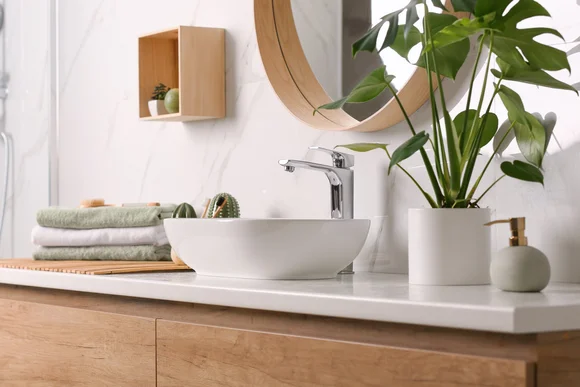 Stilvolles Badezimmer mit Waschbecken und Pflanze