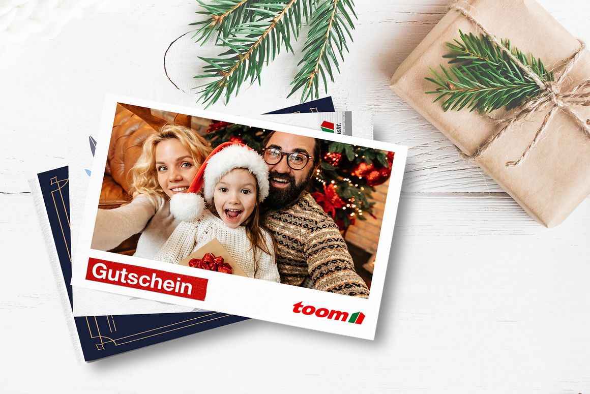 Gutscheinkarte mit Familienfoto liegt auf weihnachtlich geschmücktem Tisch.