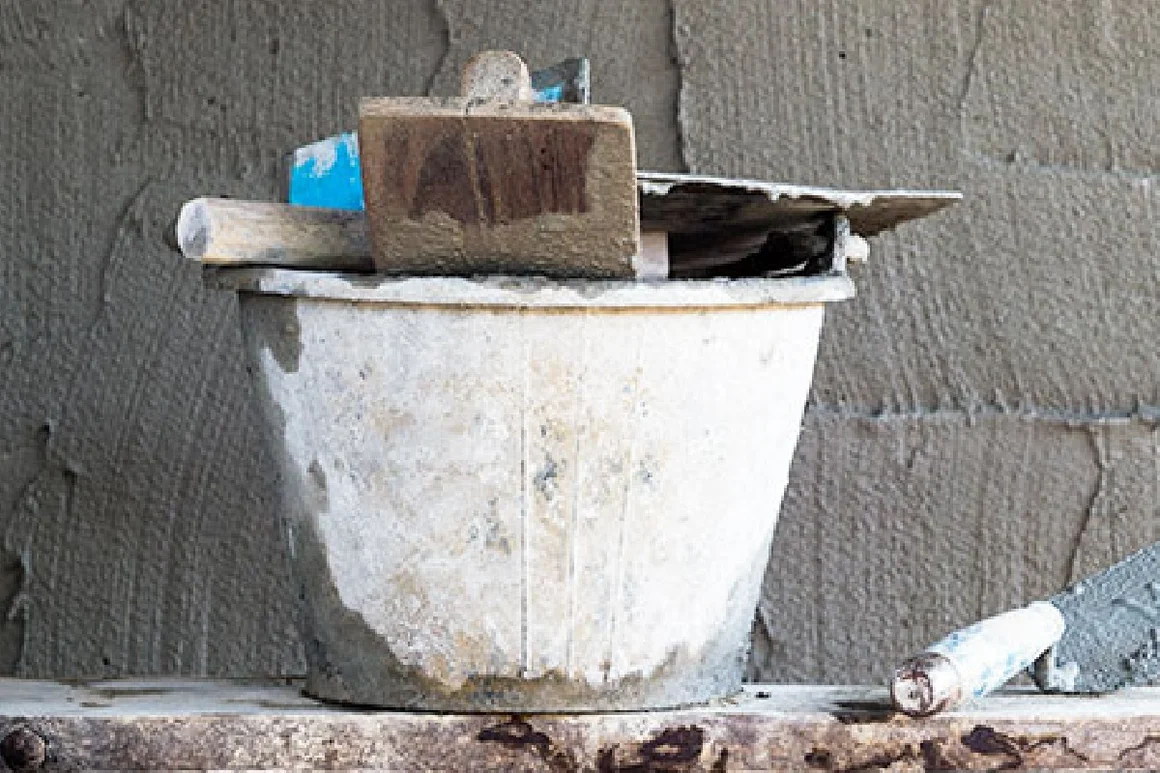 Mörtelkübel mit Kelle und Maurerkelle