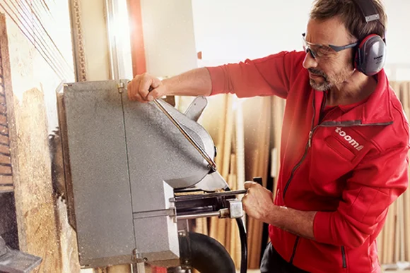 Person arbeitet mit Säge an Holz